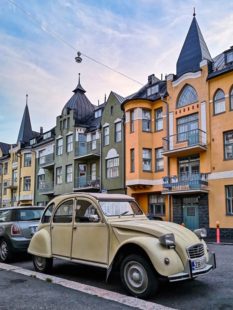 Vanhoja värikkäitä kivikerrostaloja ja vanha auto.