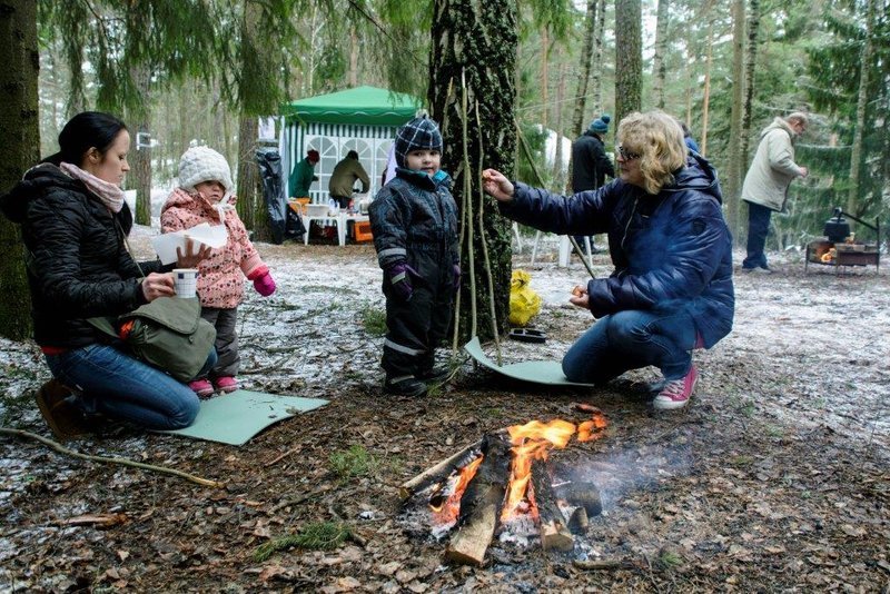 Härkämäessä koko perheen talvitapahtumassa kaksi lasta ja kaksi aikuista nuotion ympärillä.