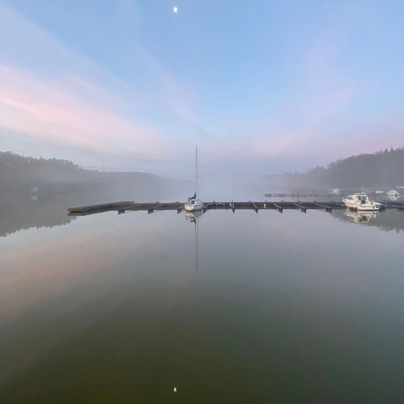 Kaarinassa Hovirinnan vierasvenesatamassa usvaisena kesäaamuna laiturissa on yksi pieni purjevene keskellä kuvaa ja laidassa muutama moottorivene.
