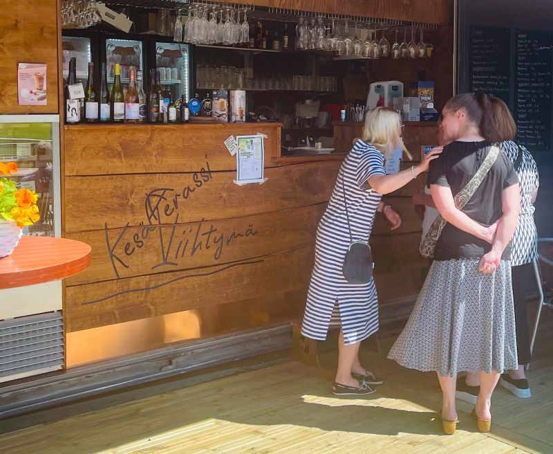 Ihmisiä Viihtymän kesäterassin tiskillä.