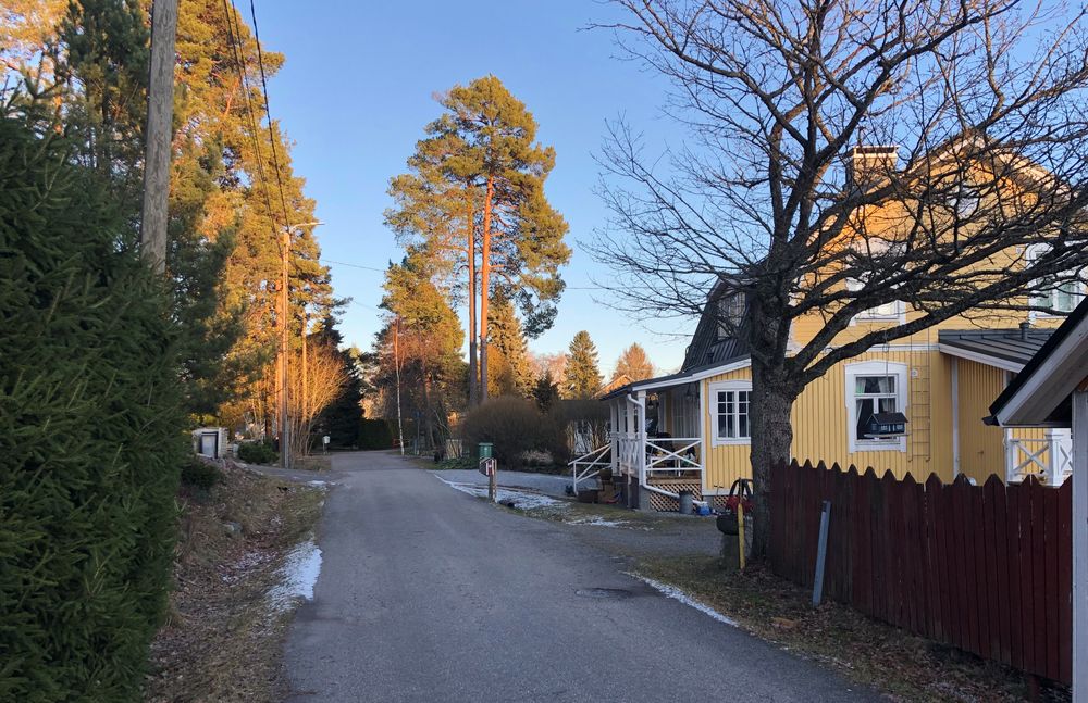 Keltainen omakotitalo pienen tien varrella Kaarinassa Littoisten asuinalueella.
