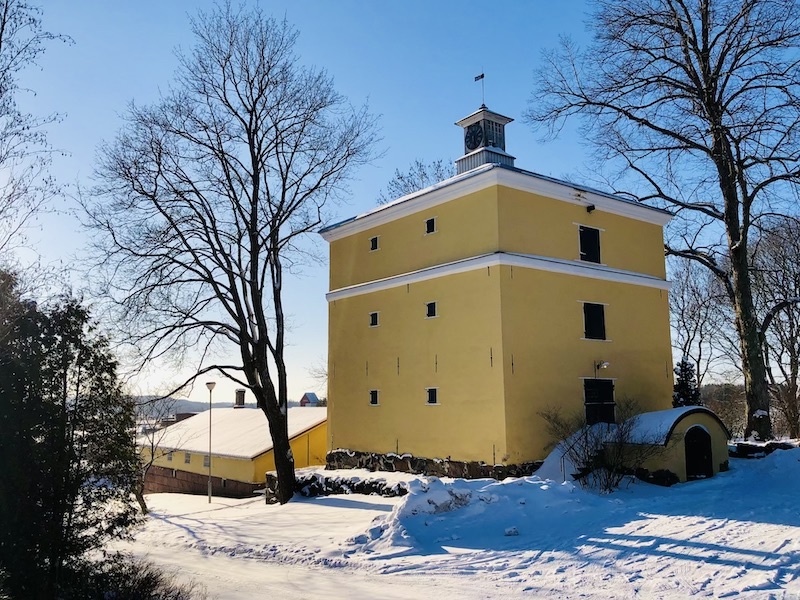 Keltainen talo Tuorlassa lumisen maiseman ympäröimänä.