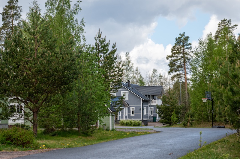 Metsän ympäröimä omakotitalo tien päässä.