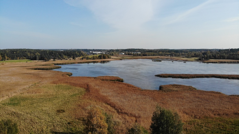 Raisionlahti ilmakuvassa ja syksyn värjäämät pellot sen ympärillä.