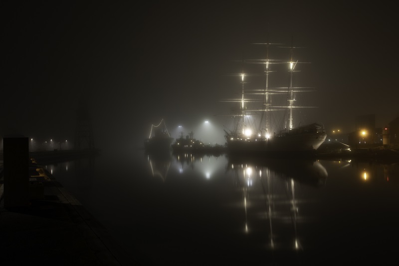 Suomen Joutsenen ja muiden laivojen valot loistavat sumun keskellä pimeässä