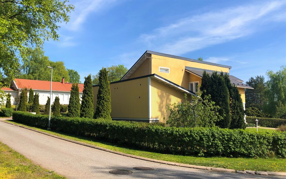 Keltainen pientalo vihreällä pihamaalla Turussa Räntämäen asuinalueella.