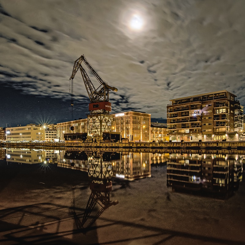 Rakennusten valot heijastuvat Aurajoen pintaan hämärässä illassa.