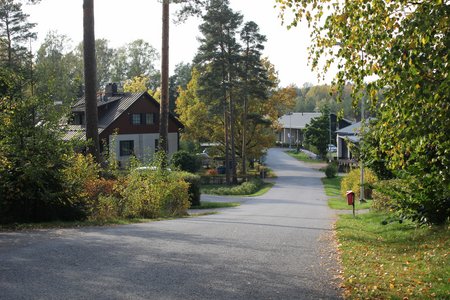Katu Ihalassa Raisiossa. Kuvassa näkyy useita omakotitaloja molemmin puolin katua. Etualalla pensaita ja puita.