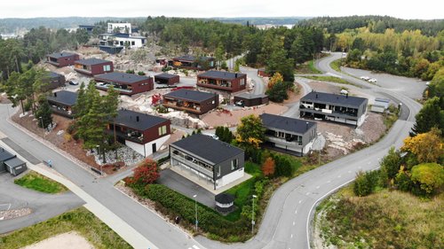 Moderneja ja tummia pientaloja Porhonkalliossa Naantalissa. Puita taka-alalla.