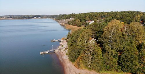 Näkymä merelle Taimon alueella Naantalissa. Rakennuksia ja metsää etualalla.