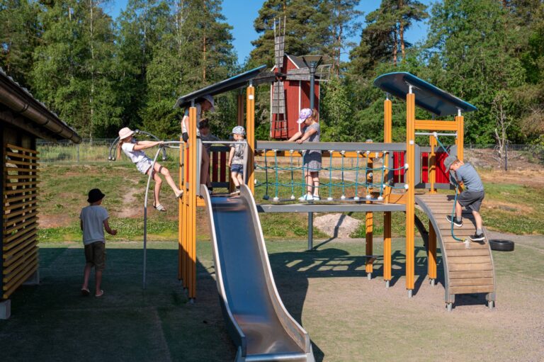 Lapsia leikkimässä leikkipuiston telineellä.