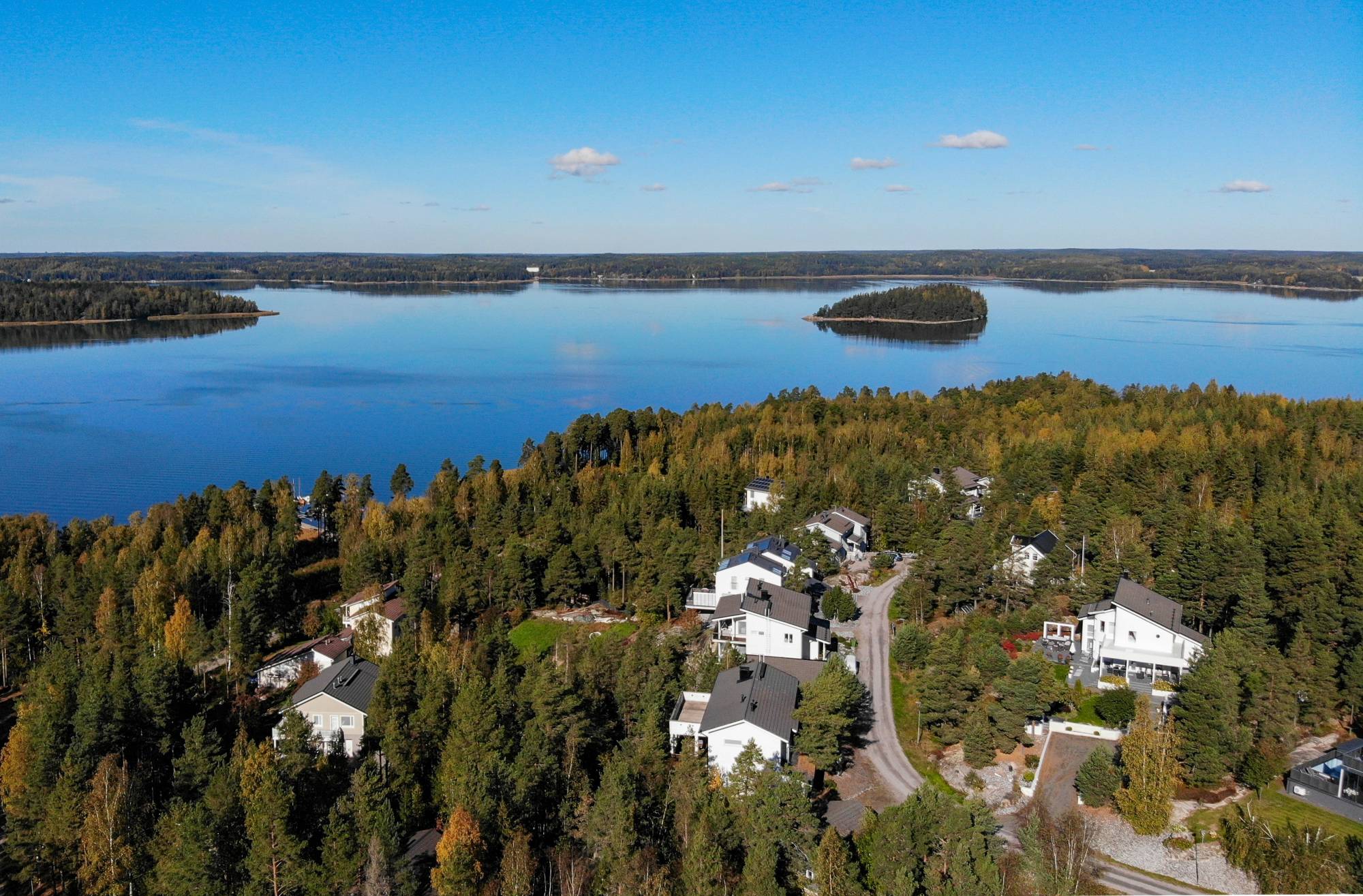 Ilmakuva Sauvon Osmalahden asuinalueesta, jossa moderneja valkoisia taloja ja taustalla meri.