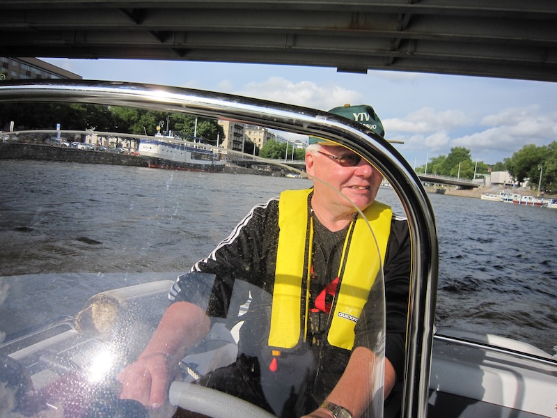 Mies ajaa venettä Turun Aurajoella. 